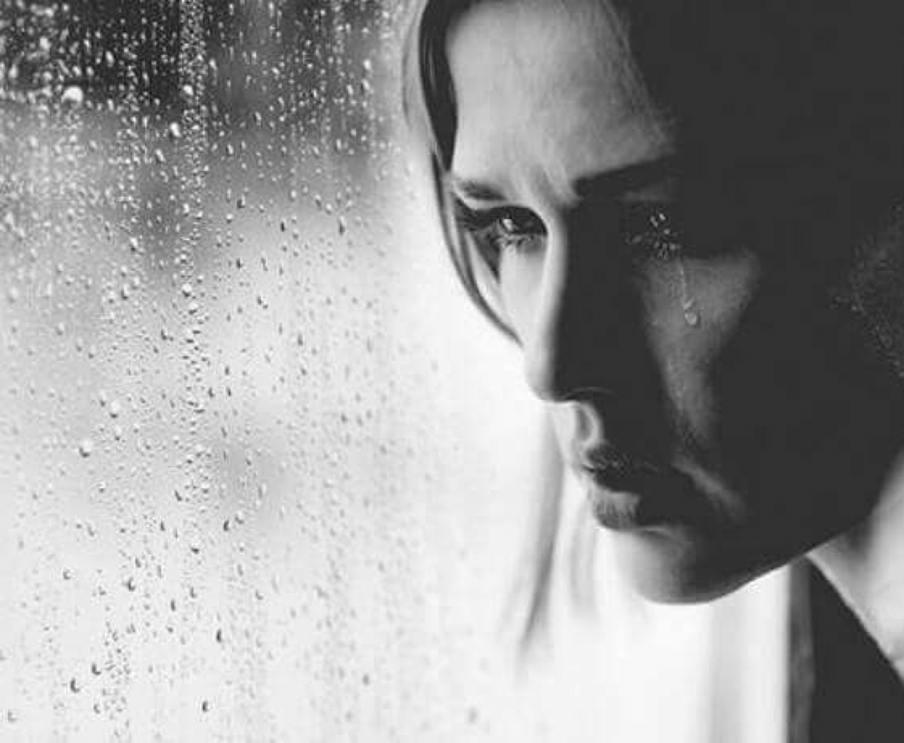 Сильная женщина плачет у окна